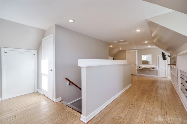 hall featuring light hardwood / wood-style floors and vaulted ceiling