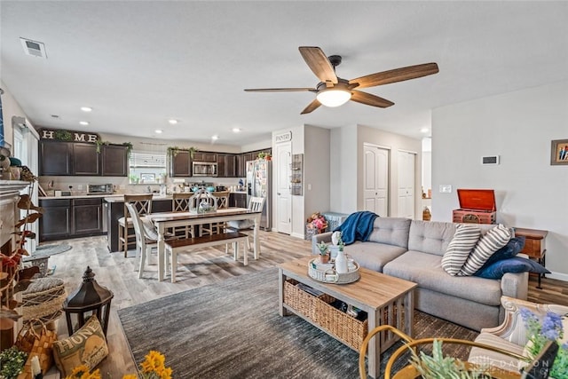 living room with ceiling fan and light hardwood / wood-style floors