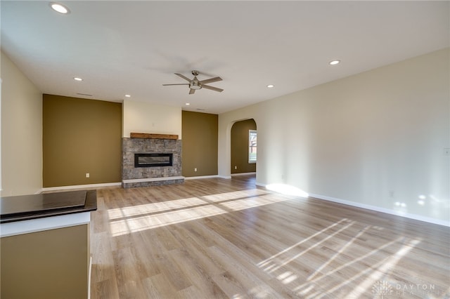 unfurnished living room with a fireplace, light hardwood / wood-style flooring, and ceiling fan