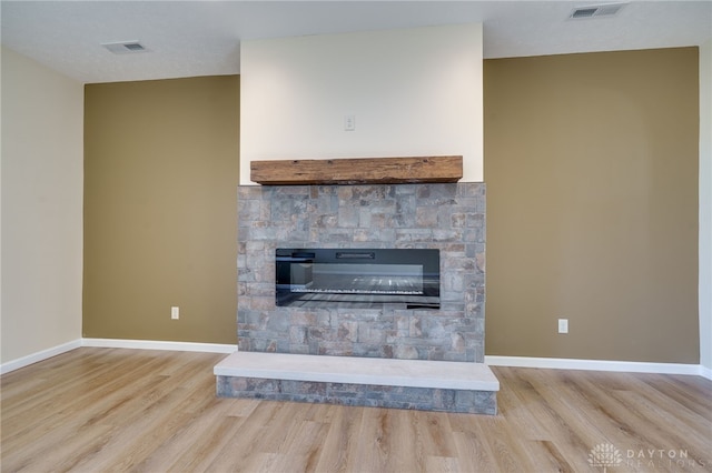 room details with a stone fireplace and hardwood / wood-style flooring