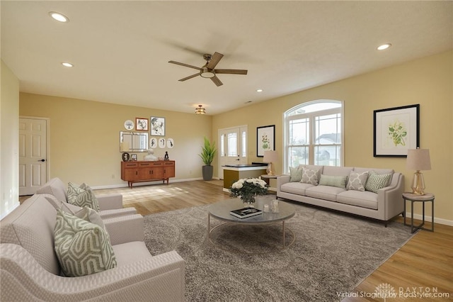 living room featuring ceiling fan and light hardwood / wood-style flooring