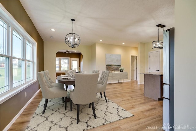 dining room with a notable chandelier and light wood-type flooring