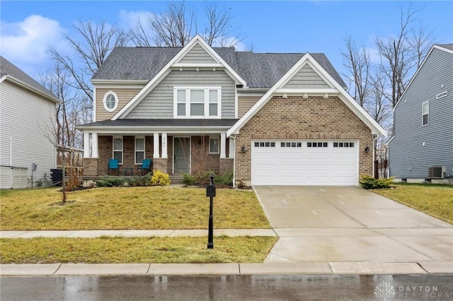 craftsman house with central air condition unit, a front lawn, and covered porch