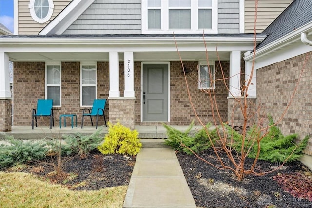 view of exterior entry featuring covered porch