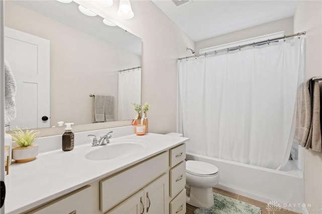 full bathroom with shower / bath combo with shower curtain, tile patterned flooring, vanity, and toilet