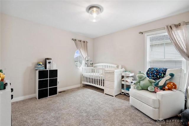 carpeted bedroom with multiple windows and a crib