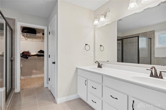 bathroom featuring tile patterned flooring, vanity, and an enclosed shower