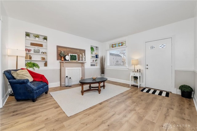 sitting room with built in shelves and light wood-type flooring