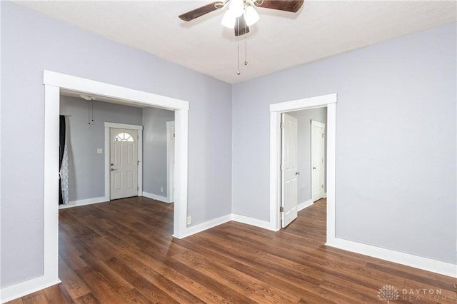 empty room with ceiling fan and dark hardwood / wood-style flooring