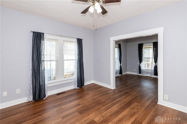 empty room with dark hardwood / wood-style floors and ceiling fan