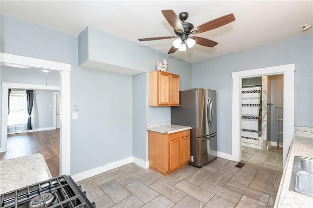 kitchen with stainless steel refrigerator, ceiling fan, and sink