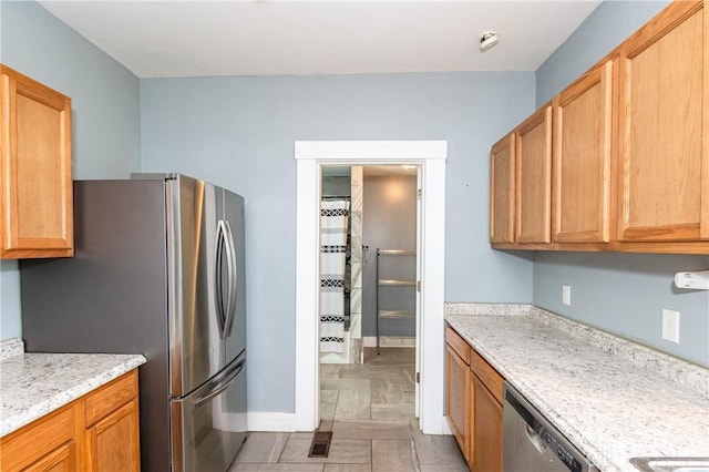 kitchen featuring light stone countertops and appliances with stainless steel finishes