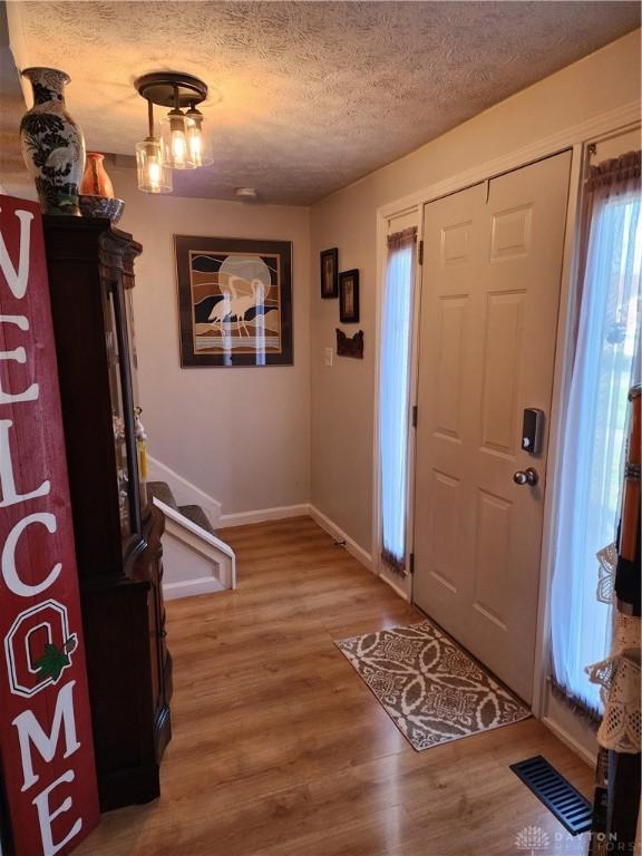 entrance foyer with wood-type flooring and a textured ceiling