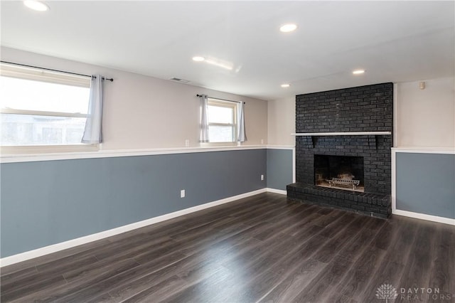 unfurnished living room with a fireplace and dark wood-type flooring