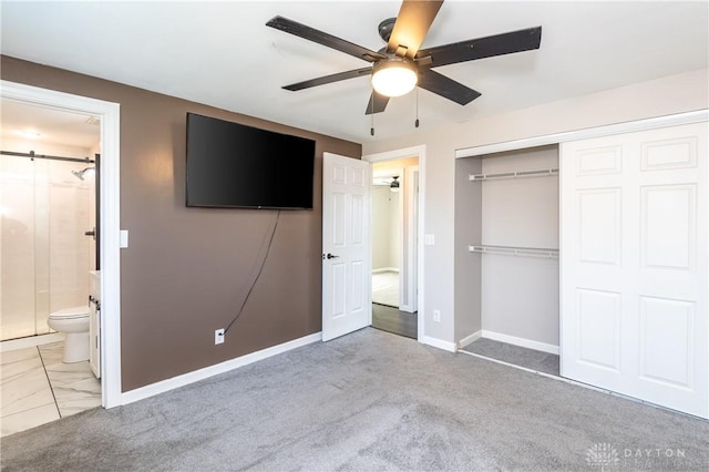 unfurnished bedroom featuring connected bathroom, ceiling fan, a closet, and light colored carpet