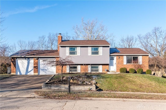 tri-level home featuring a front yard and a garage