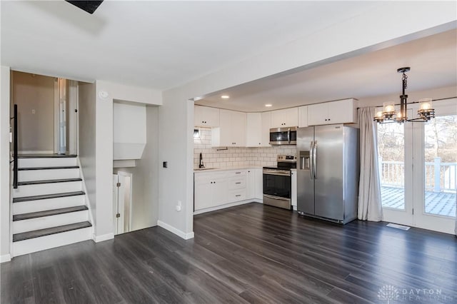 kitchen with white cabinets, stainless steel appliances, and dark hardwood / wood-style floors