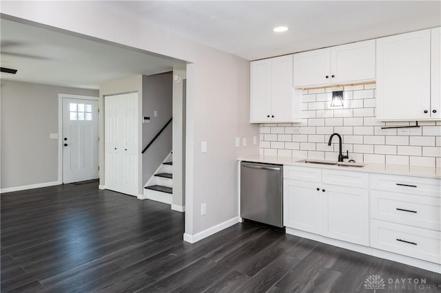 kitchen with dishwasher, white cabinets, sink, dark hardwood / wood-style floors, and tasteful backsplash