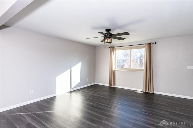 empty room with dark hardwood / wood-style flooring and ceiling fan