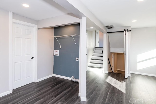 interior space featuring a barn door and dark hardwood / wood-style flooring