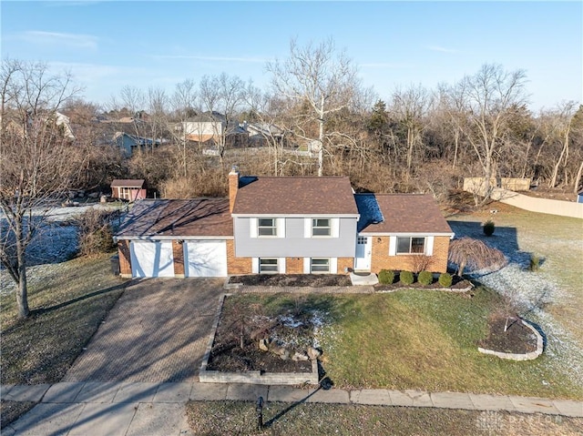 tri-level home with a garage and a front yard