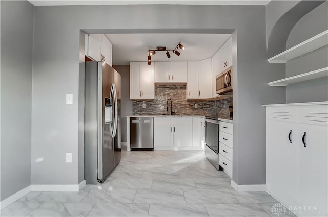 kitchen with white cabinets, backsplash, sink, and appliances with stainless steel finishes