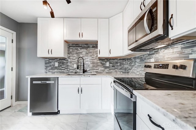 kitchen featuring decorative backsplash, white cabinetry, sink, and stainless steel appliances