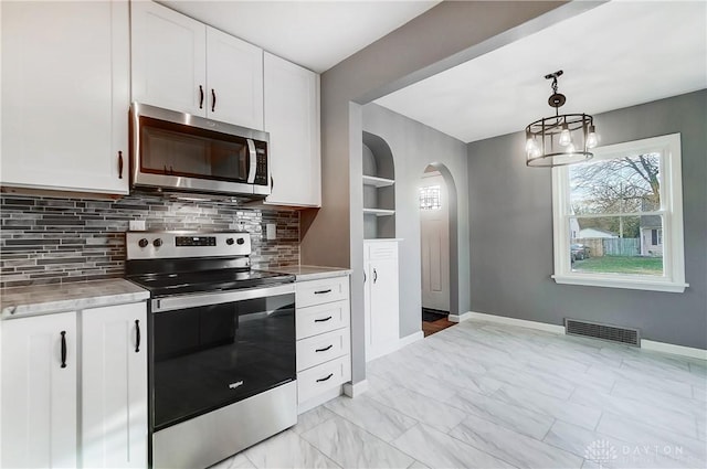 kitchen with white cabinetry, built in features, backsplash, decorative light fixtures, and appliances with stainless steel finishes