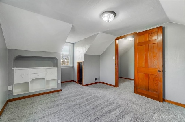 bonus room featuring light carpet and vaulted ceiling