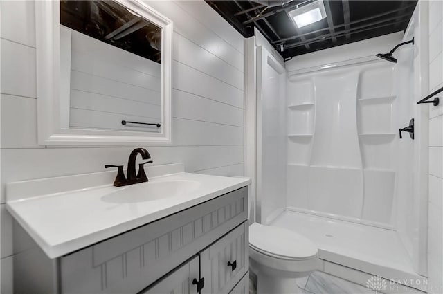 bathroom with vanity, toilet, and a shower