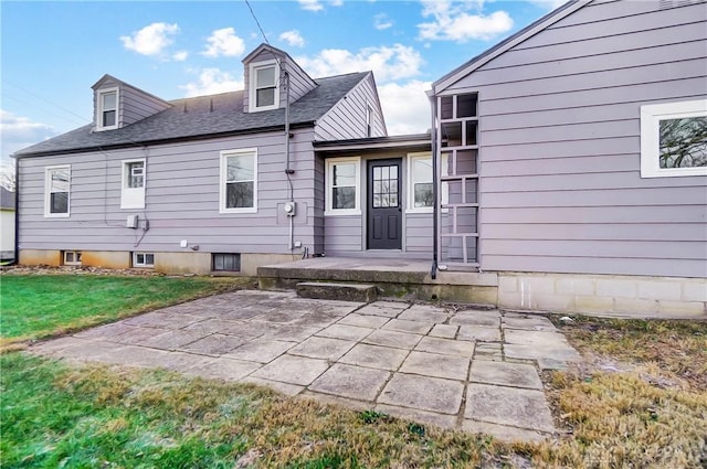 back of property featuring a patio area and a lawn