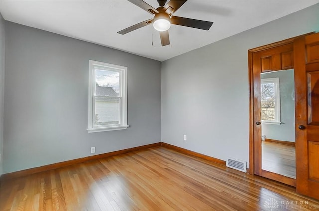 unfurnished room featuring a wealth of natural light, ceiling fan, and light hardwood / wood-style floors