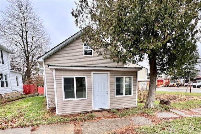 back of house with fence and a yard