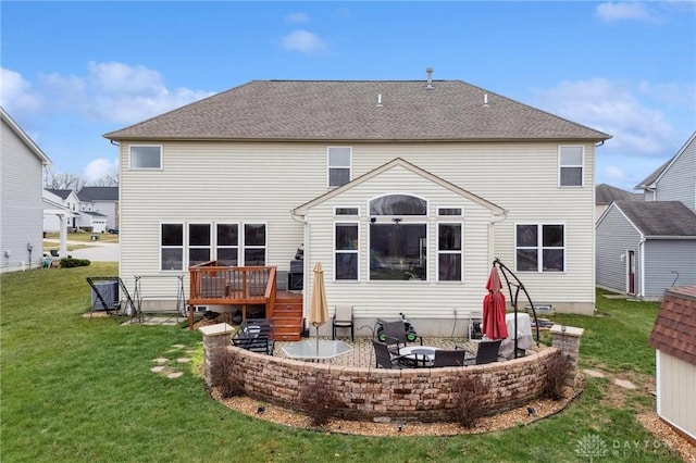 rear view of house featuring a yard, a patio area, and a wooden deck