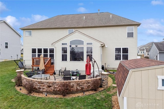 back of property featuring a patio area and a yard