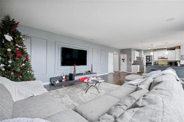 living room with dark hardwood / wood-style flooring and sink