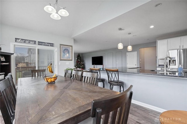 dining area featuring a chandelier, dark wood-type flooring, and sink