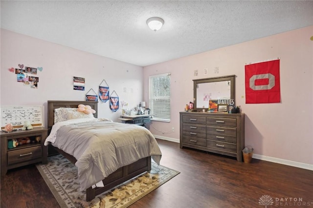 bedroom with a textured ceiling and dark wood-type flooring