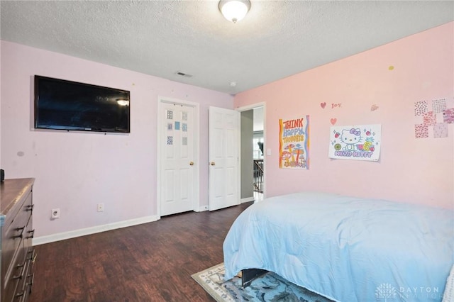 bedroom with a textured ceiling and dark hardwood / wood-style flooring