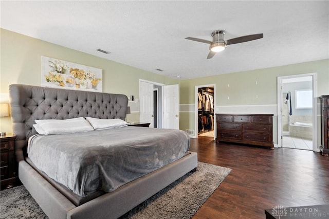 bedroom with ceiling fan, a spacious closet, dark hardwood / wood-style flooring, ensuite bathroom, and a closet