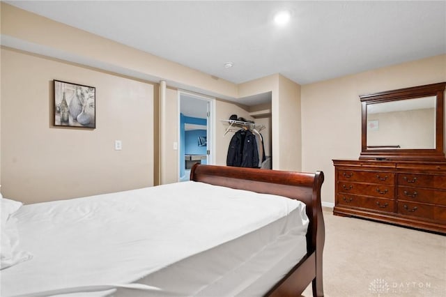 carpeted bedroom with a walk in closet and a closet