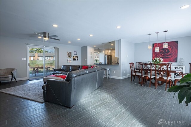 living room featuring baseboards, dark wood finished floors, and recessed lighting