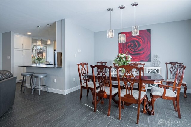 dining room featuring dark wood-style flooring and baseboards