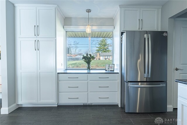 kitchen featuring dark countertops, wood tiled floor, white cabinets, and freestanding refrigerator