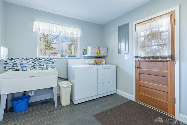 washroom featuring wood finish floors, laundry area, electric panel, independent washer and dryer, and baseboards