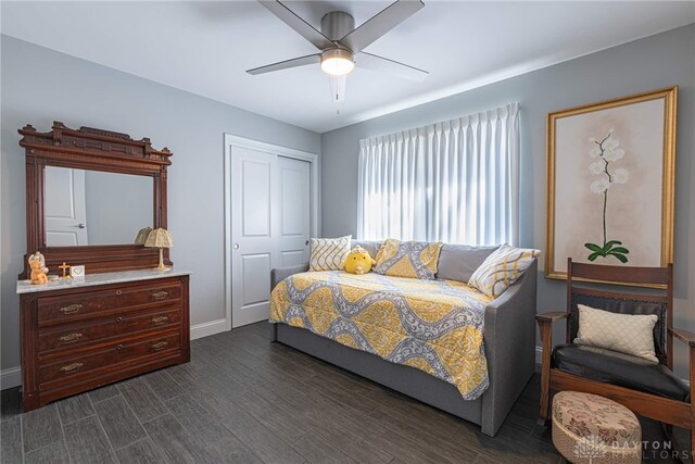 bedroom with dark wood-style floors, ceiling fan, baseboards, and a closet