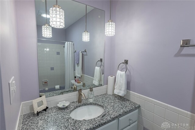 full bathroom featuring tile walls, vanity, and a shower with shower curtain