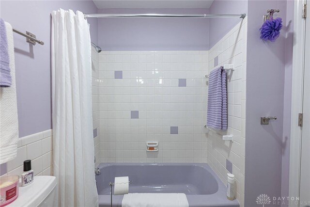 full bathroom featuring shower / tub combo with curtain and toilet