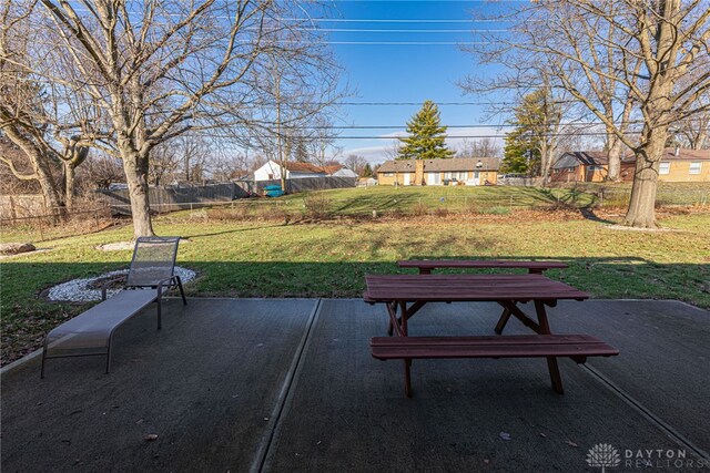 view of home's community featuring fence, a lawn, and a patio