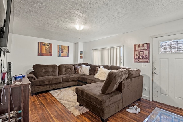 living room with dark hardwood / wood-style flooring and a textured ceiling